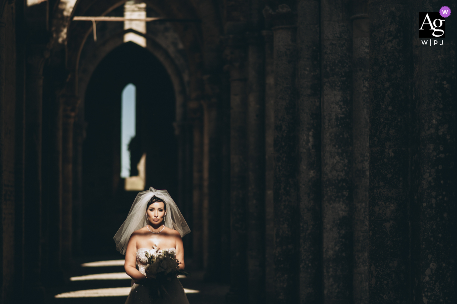 the bride standing in sunlight holding flowers